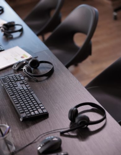 Empty helpdesk office with telephony equipment at reception to give assistance. No people in telemarketing space for customer service and client support, remote helpline headphones.